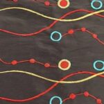 Black, yellow, red, and green taffeta wave and circle print tablecloth and runner.